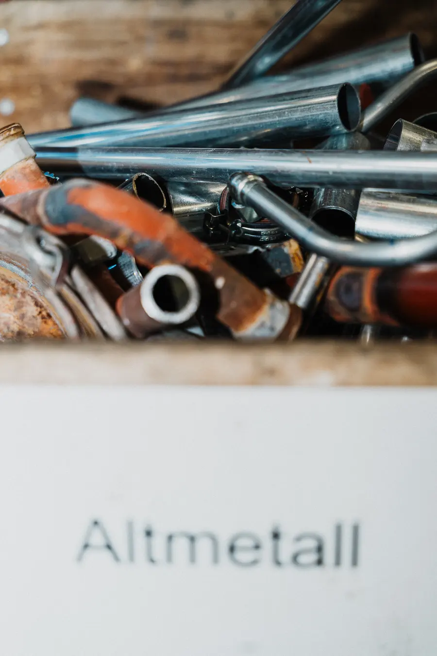 Kiste mit ausgedienten Rohren, beschriftet mit Altmetall