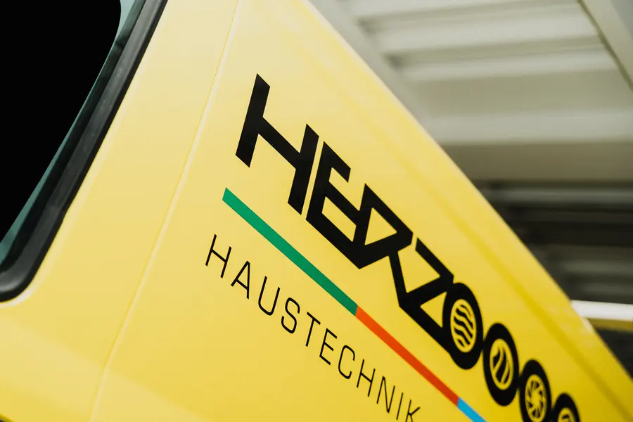 Herzog-Logo auf der Seite eines gelben Servicefahrzeugs