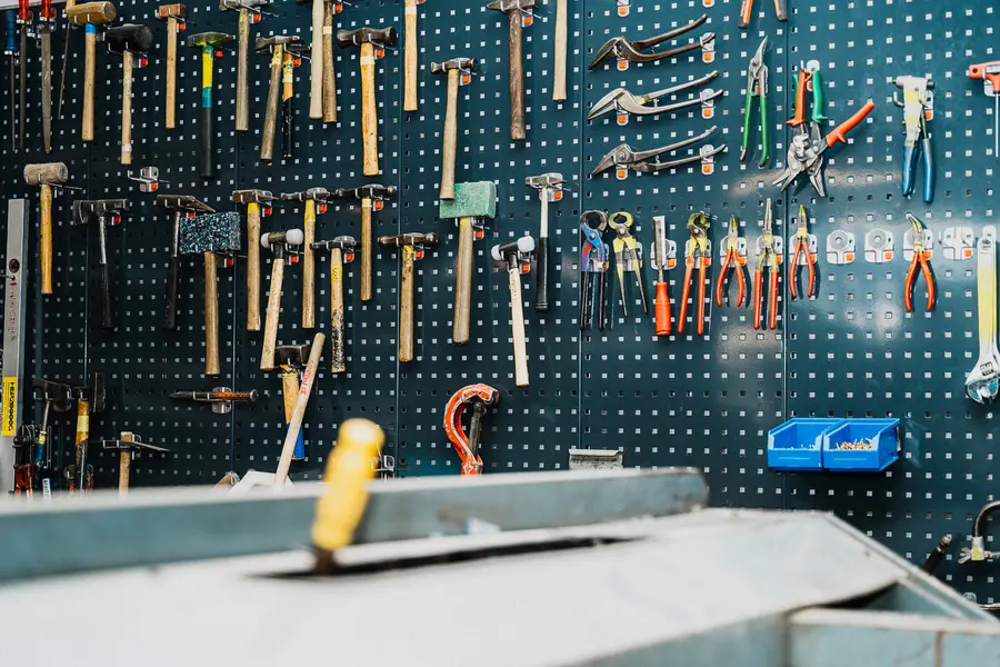 Werkzeugwand mit Hämmern, Zangen und Sägen in der Werkstatt