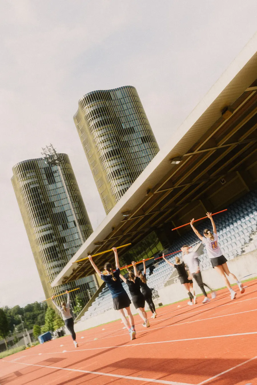 Laufende mit erhobenen Stäben gehen die Stadionbahn entlang
