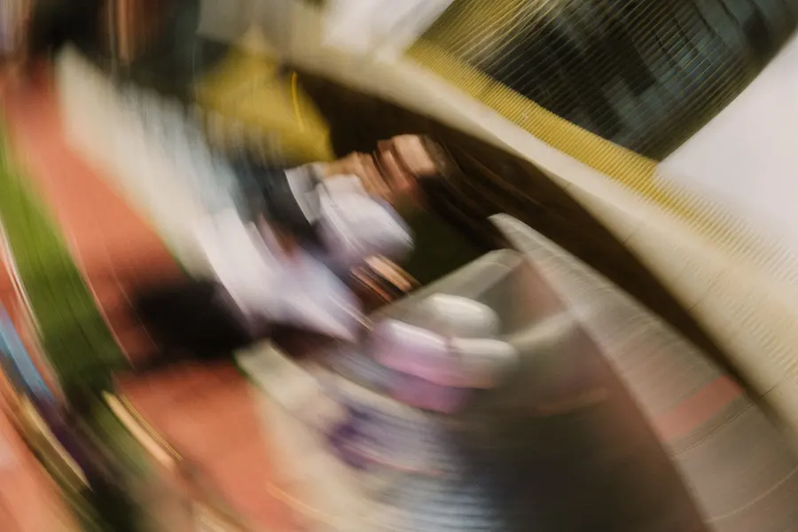 Abstrakte Bewegungsunschärfe mit Stadiondach und vorbeilaufenden Personen