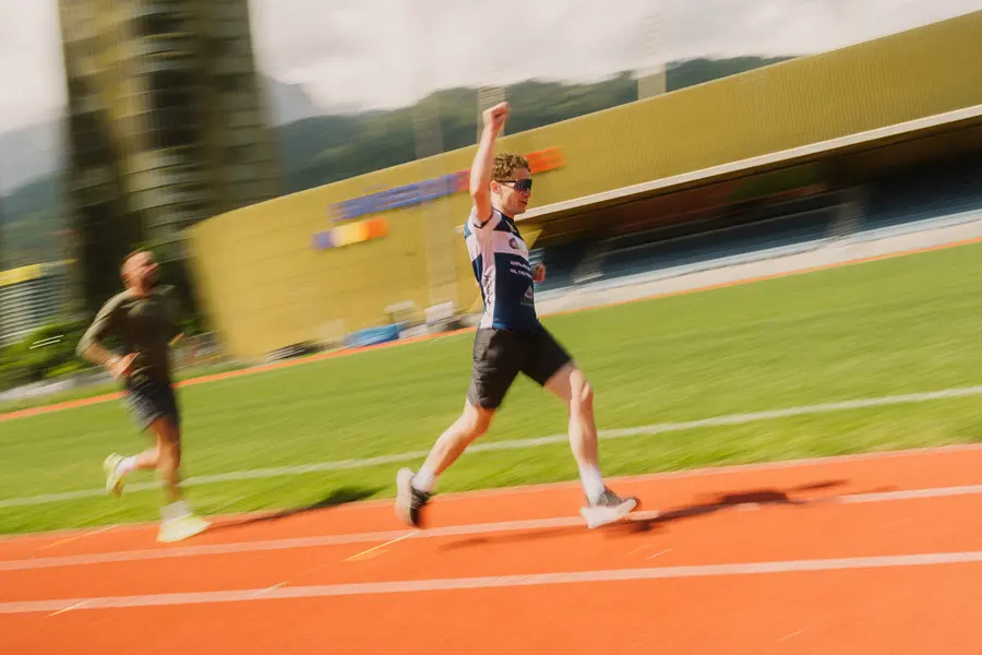 Läufer reckt beim Lauf vor dem Stadion den Arm in die Höhe