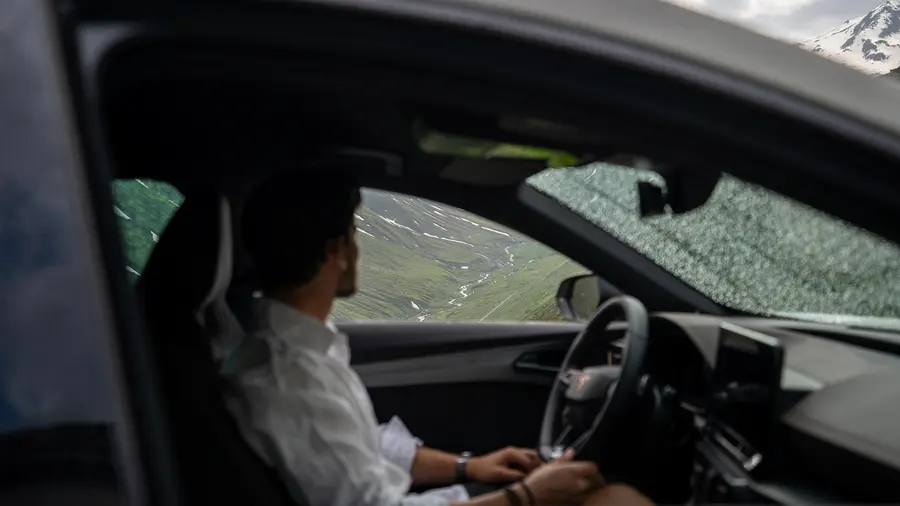 Conducteur au volant regardant les pentes vertes de la montagne