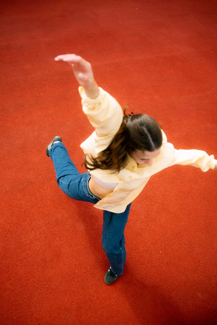Danseuse en plein pas, bras écartés, photographiée d’en haut