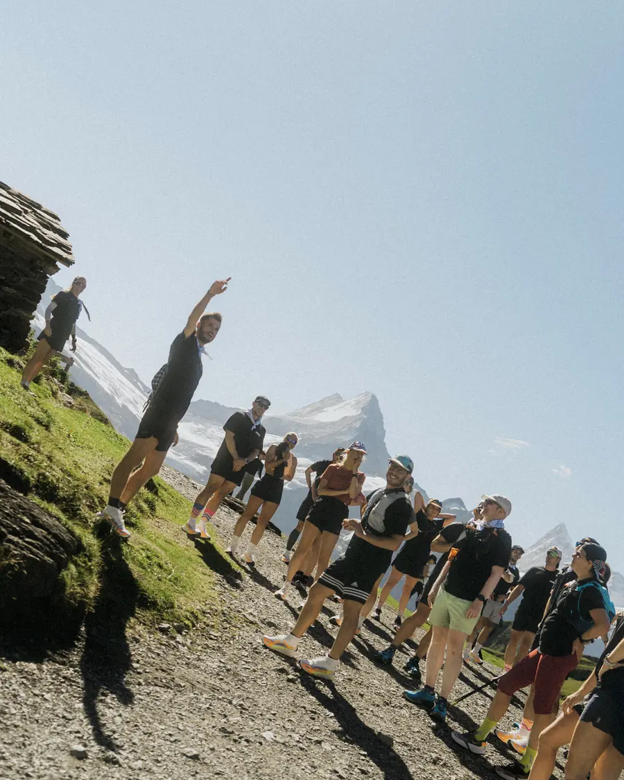 Ein Teilnehmer zeigt in den Himmel, die Gruppe steht auf dem Bergweg