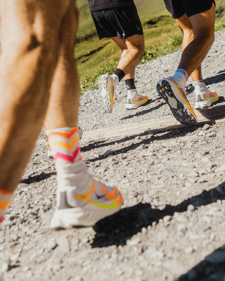 Tecton X 4 mit bunt gestreiften Socken beim Abdruck auf Schotter