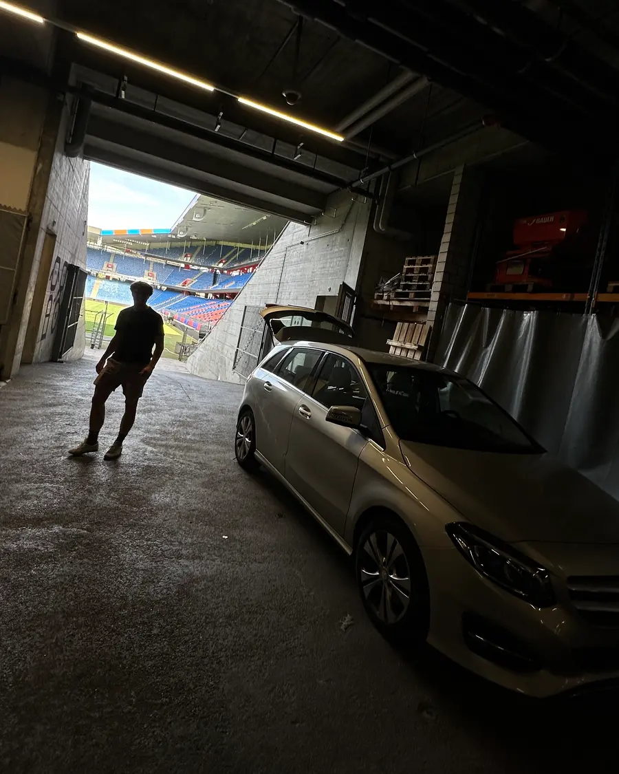 Im Tunnel eines Fussballstadions: ein Auto mit offenem Kofferraum, hinten die Tribünen