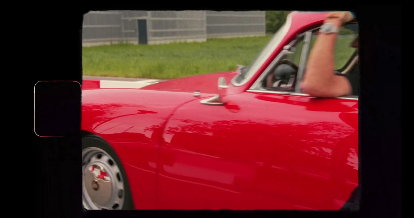 Porsche 911 classique rouge en mouvement, le bras du conducteur à la fenêtre