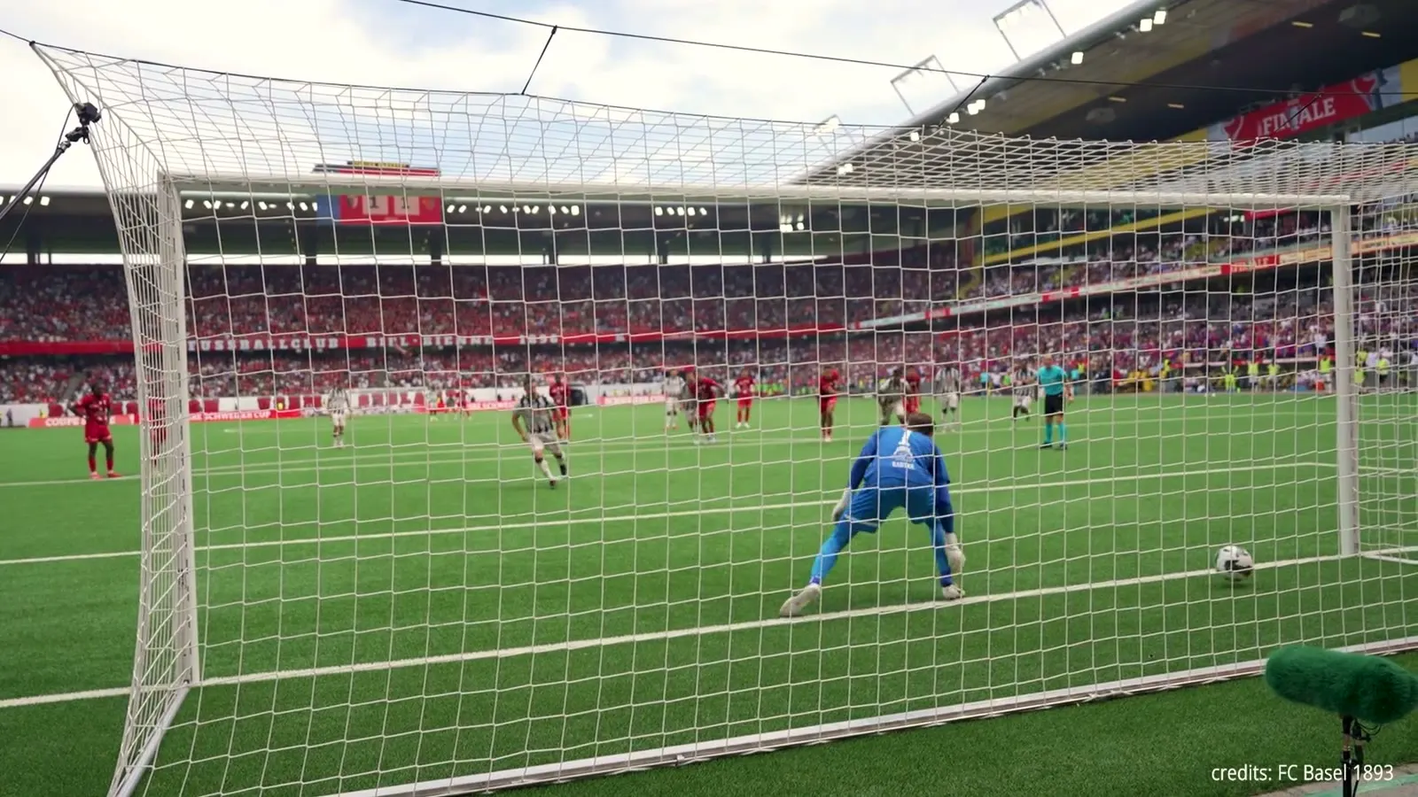 Blick hinter dem Tor auf einen Penalty im vollen Stadion